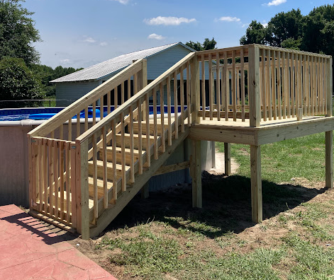 Elevated above-ground pool deck with long staircase and full railing